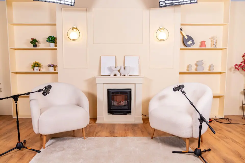 Set Le Cocon, deux fauteuils bouclette blancs devant une cheminée